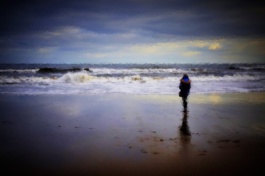 Person on the beach watching the sea