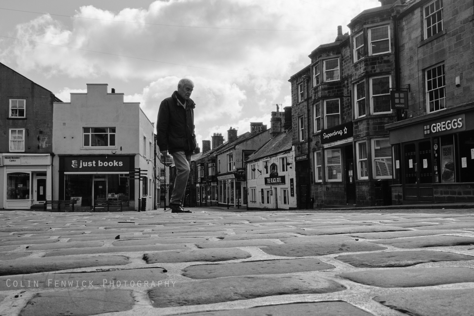 man walkiong alone in a town square