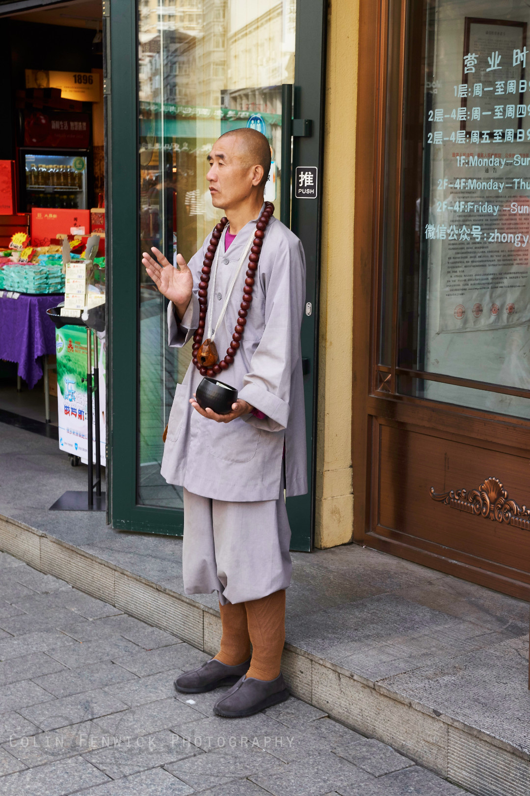 Monk in front of shop