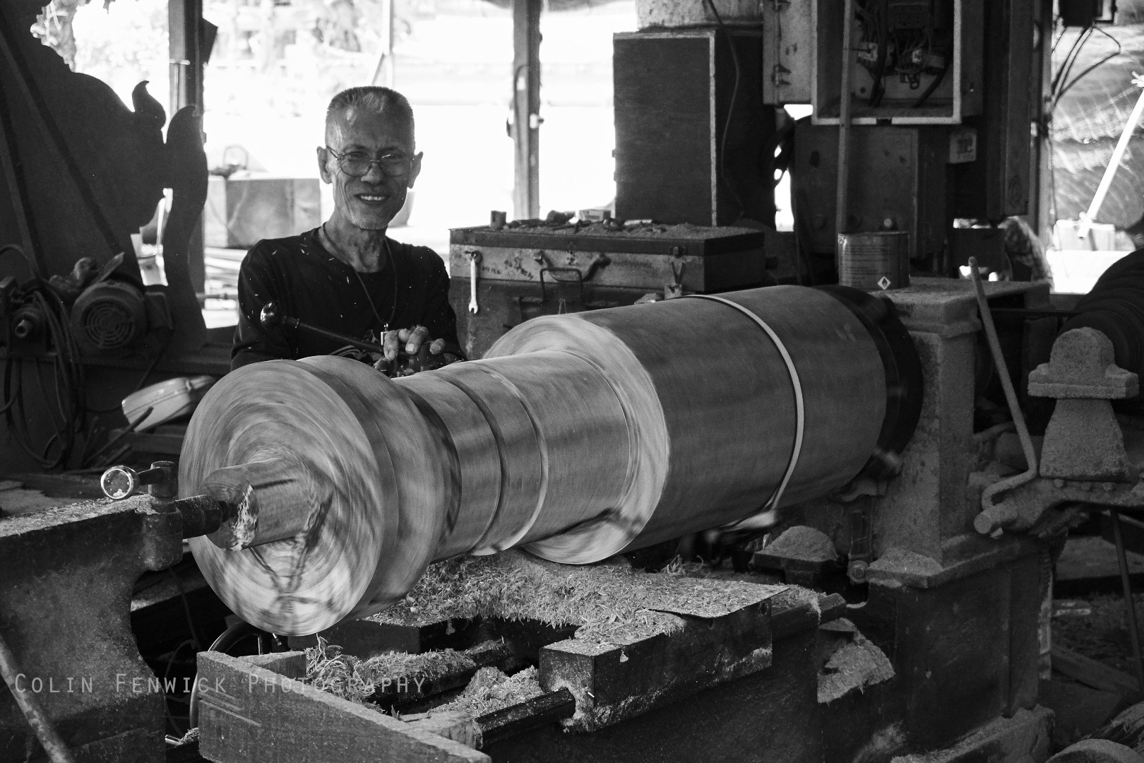 A man turns wood on a lathe