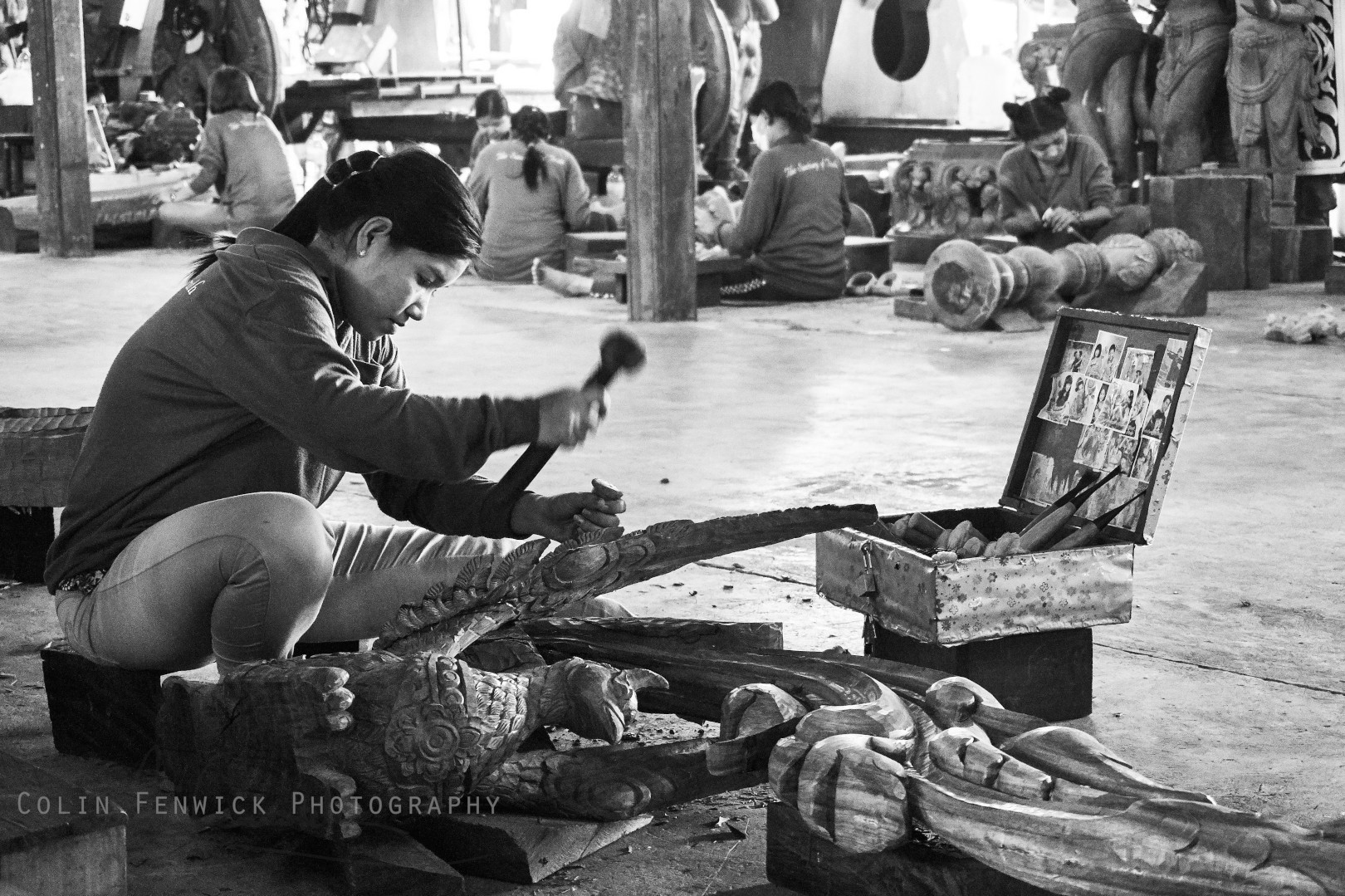 Woman carves wooden ornament