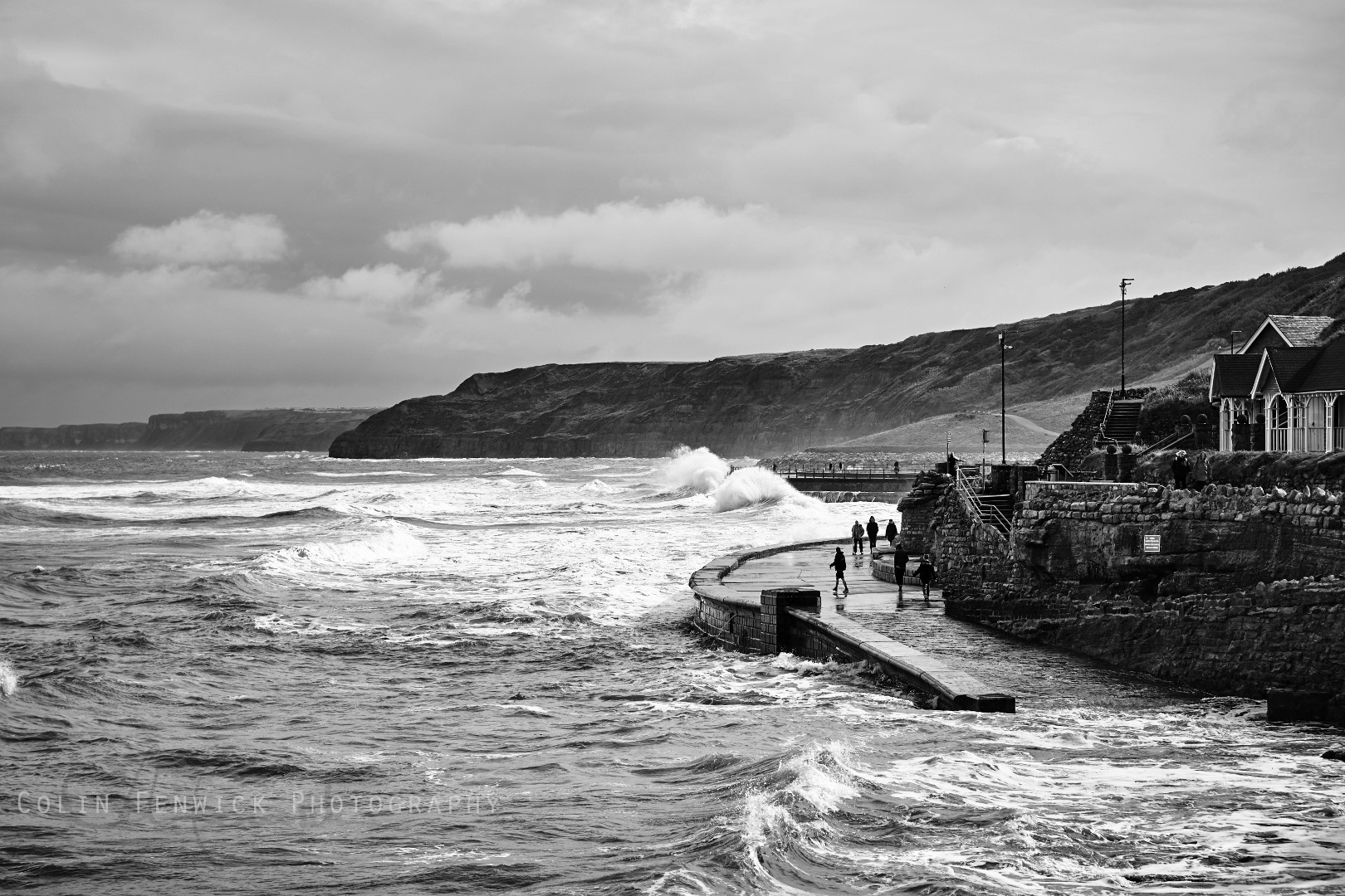 Waves crash against a sea wall