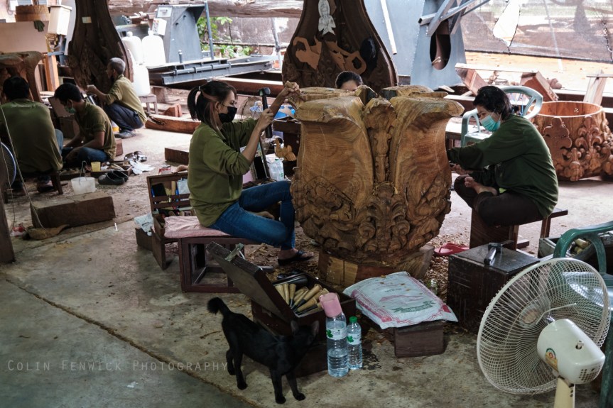 Workers hand carving wood