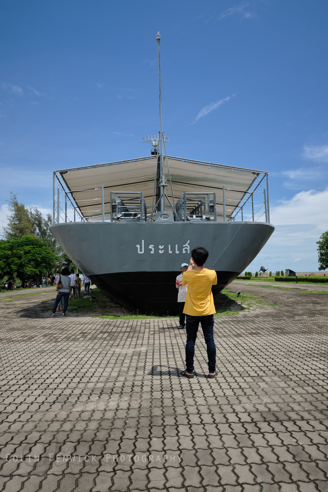Tourists take photos at the stern of HTMS Prasae
