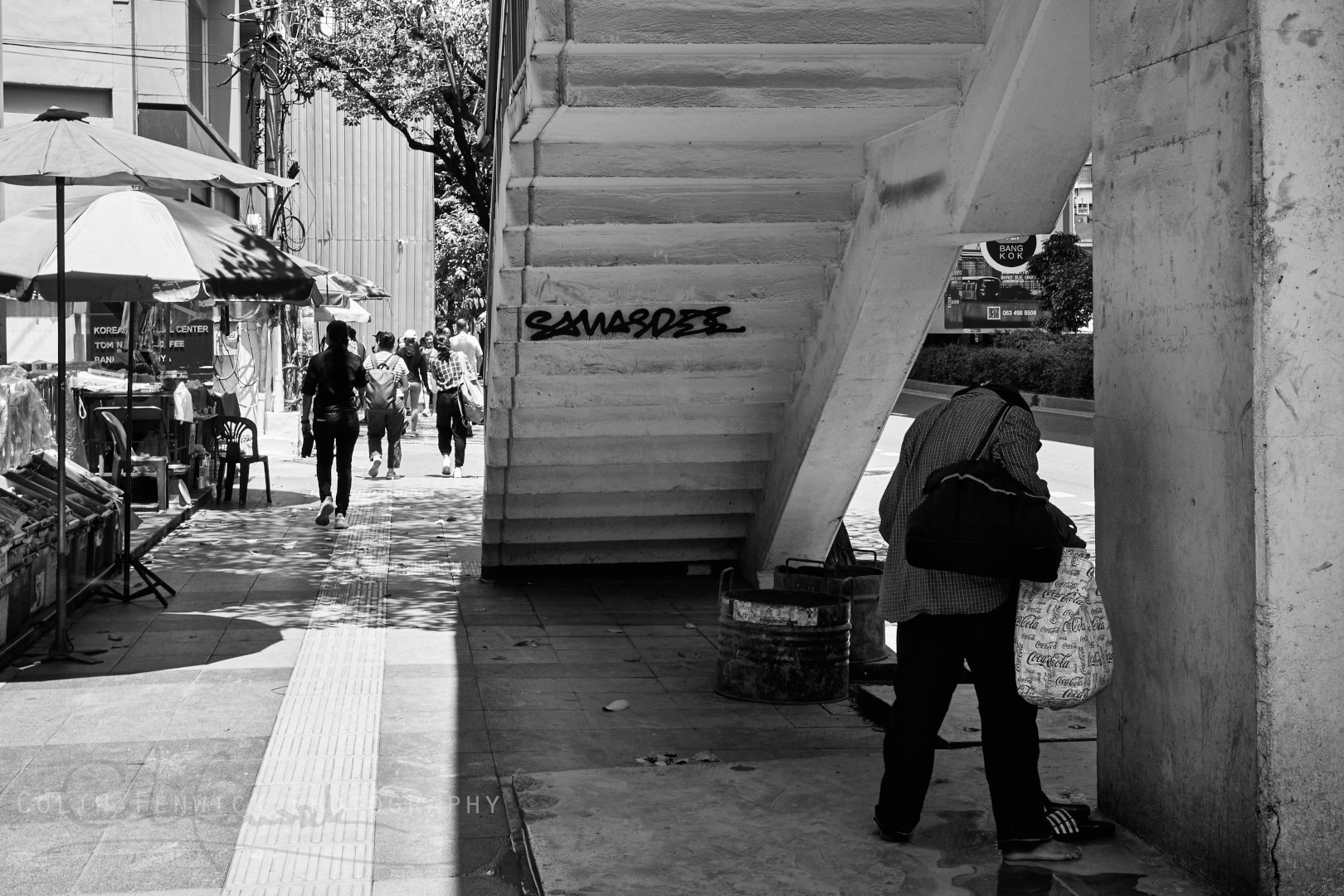 Man shelters under steps to the Asok skybridge