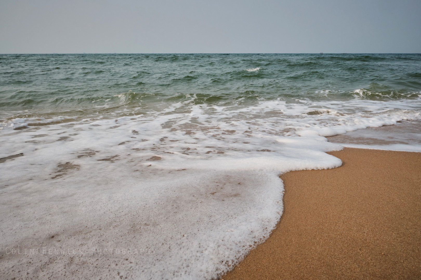 Waves roll over a sandy beach
