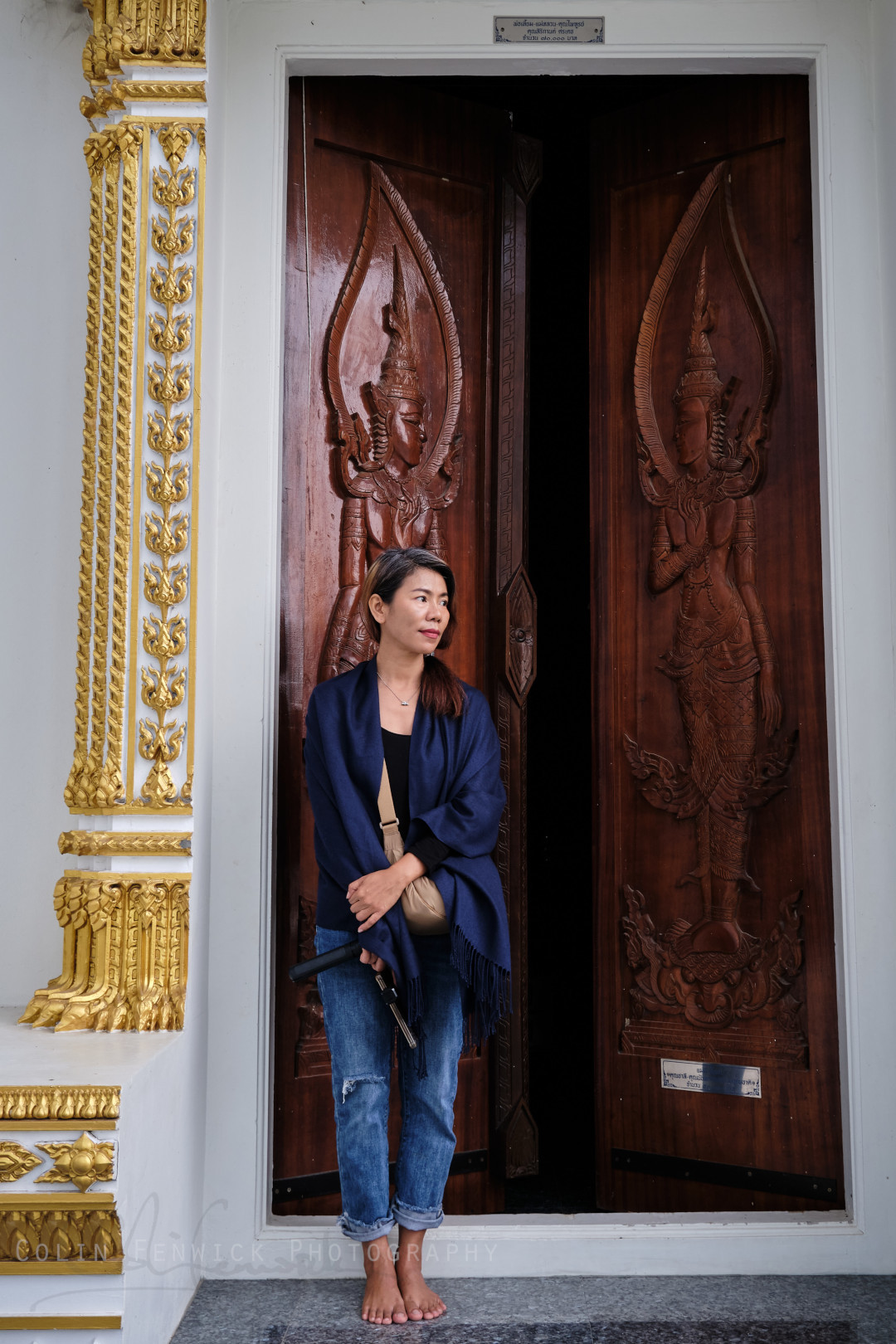 Woman stands in front of carved wooden doors
