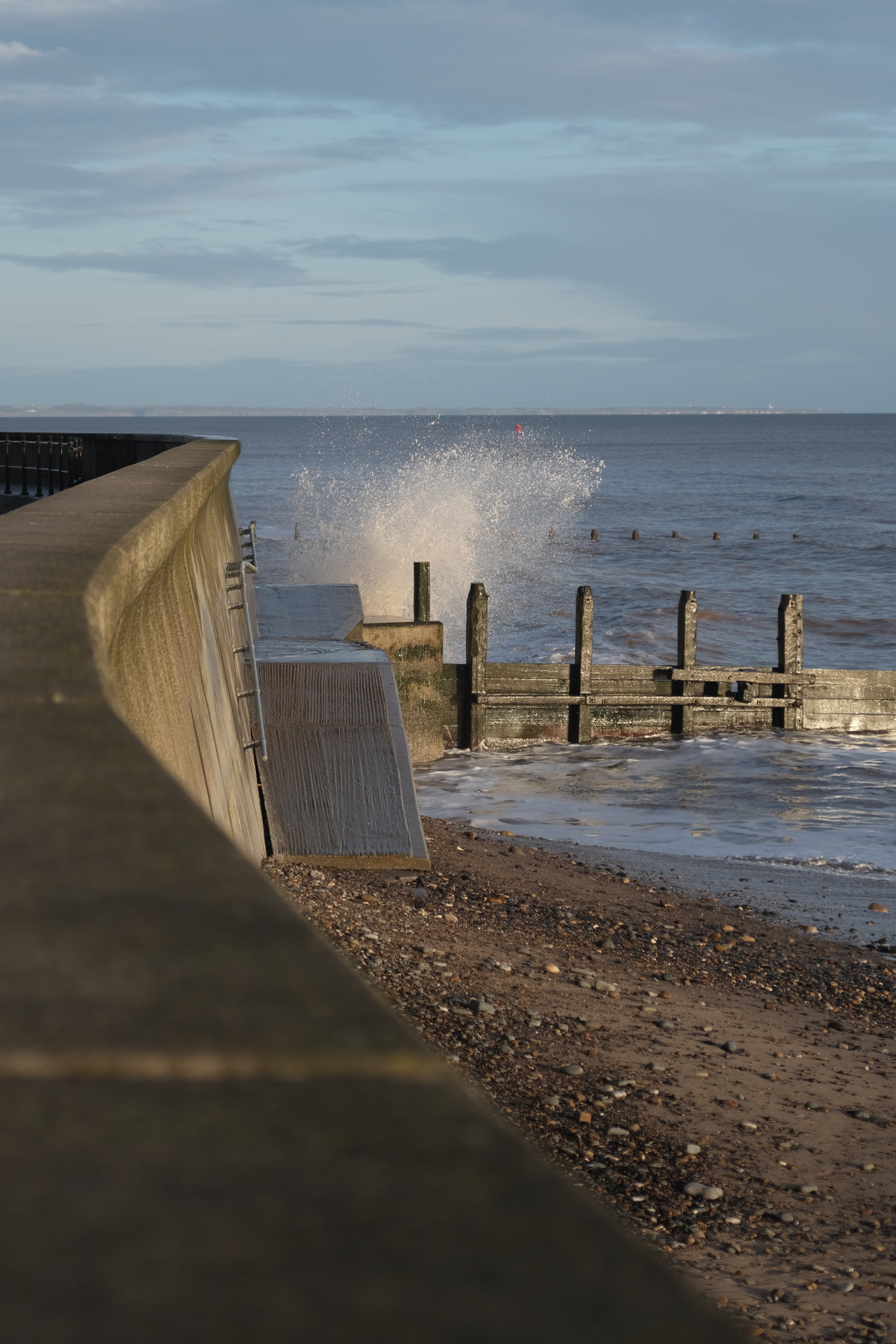 Wave splashes against sea wall