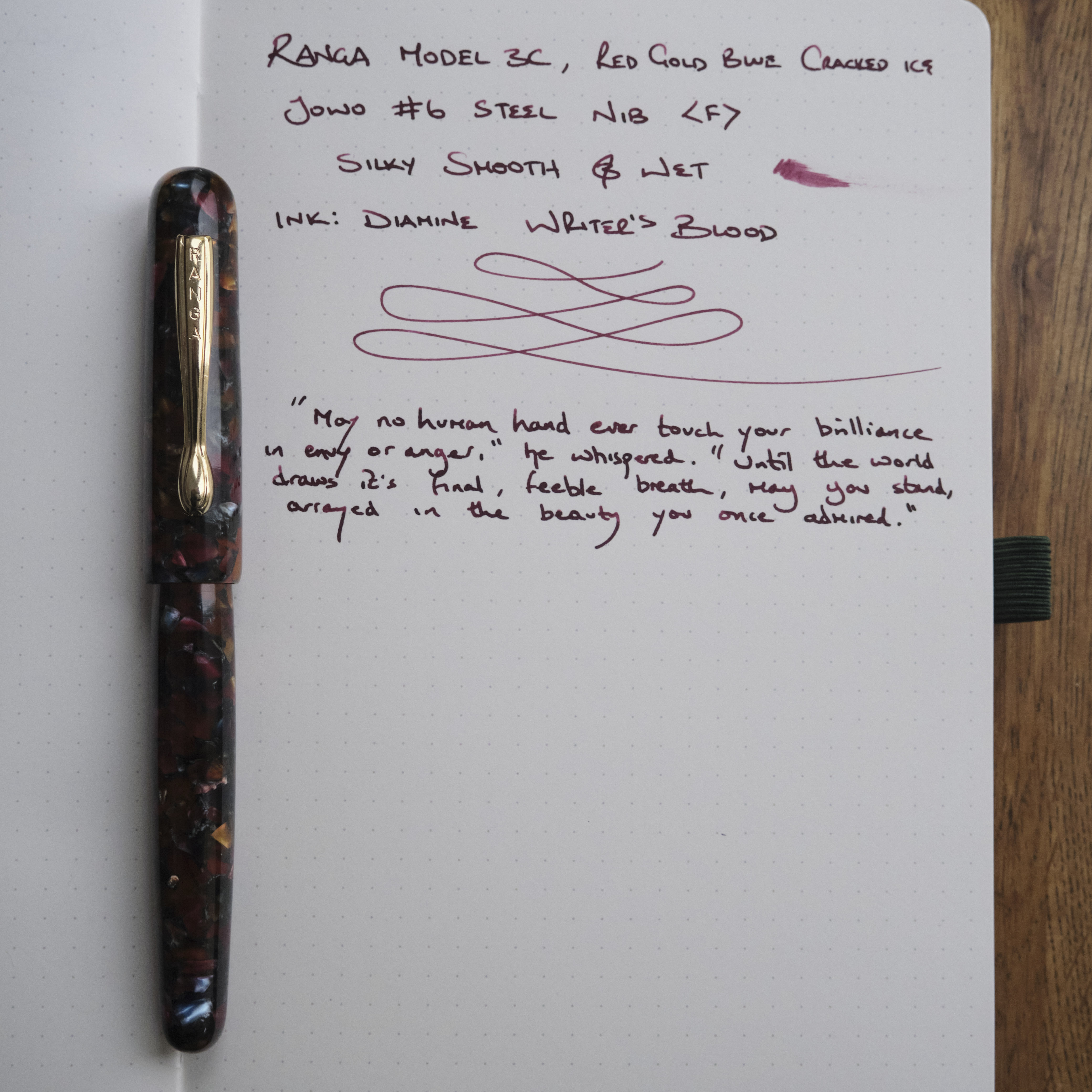 Fountain pen on notepad with writing sample